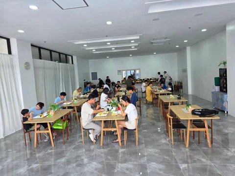학생들이 나무 테이블에 앉아 식사하는 토크 어학원 식당