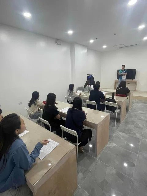 토크 어학원 그룹 강의실에서 학생들이 책상에 앉아 강사 수업을 듣는 모습