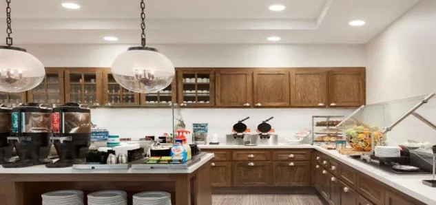 Homewood Suites 조식 공간의 커피·와플 기계와 뷔페 카운터